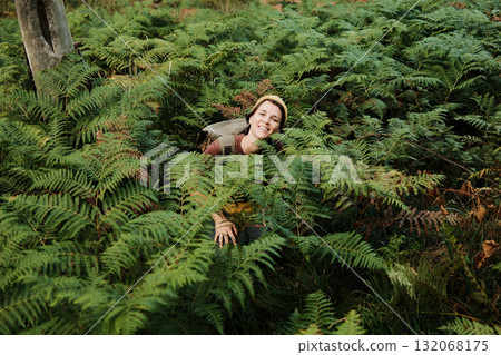 Smiling woman sitting in ferns during hike in Divcibare, Serbia. Hiking and travel outdoor concept 132068175