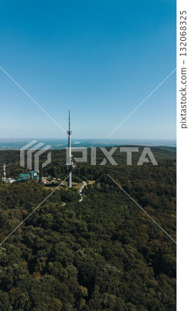 Aerial view of TV tower Iriski Venac rising above the forested hills of Fruska Gora National Park with panoramic landscapes. Was damaged by a NATO missile during the Yugoslav War Aerial view of TV tower Iriski Venac rising above the forested hills of Fruska Gora National Park with panoramic landscapes. Was damaged by a NATO missile during the Yugoslav War 132068325