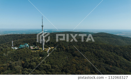 Aerial view of TV tower Iriski Venac rising above the forested hills of Fruska Gora National Park with panoramic landscapes. Was damaged by a NATO missile during the Yugoslav War Aerial view of TV tower Iriski Venac rising above the forested hills of Fruska Gora National Park with panoramic landscapes. Was damaged by a NATO missile during the Yugoslav War 132068327