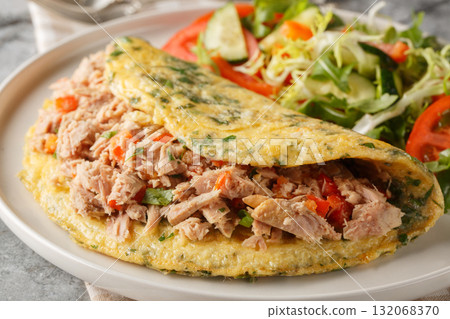 Breakfast Omelet with canned tuna and fresh vegetables salad closeup on the plate. Horizontal 132068370