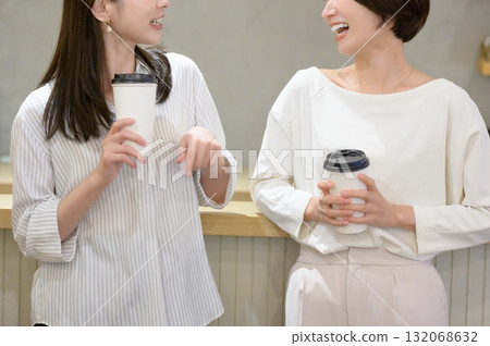 Women having a conversation while drinking coffee in a cafe Women having a conversation while drinking coffee in a cafe 132068632