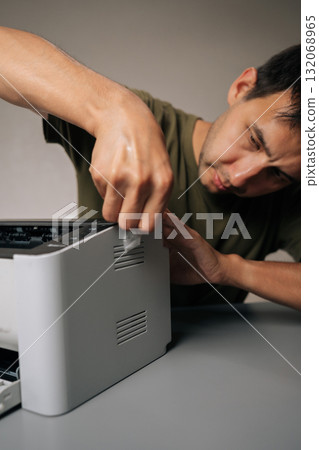 Focused technician meticulously cleaning printer with cloth, performing routine maintenance on essential office equipment, ensuring smooth operation and preventing malfunctions on isolated background Focused technician meticulously cleaning printer with cloth, performing routine maintenance on essential office equipment, ensuring smooth operation and preventing malfunctions on isolated background 132068965