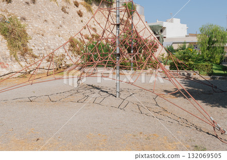 Playground climbing structure in city park shaped like pyramid. 132069505
