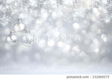 Christmas ornaments hang sparkling on a snowy background with bright lights. 132069573