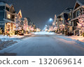 A peaceful street glows with Christmas lights on a snowy winter night. 132069614