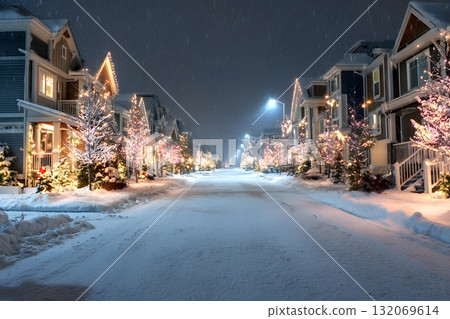 A peaceful street glows with Christmas lights on a snowy winter night. 132069614