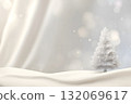 Christmas tree stands in soft snow with gentle falling snow. 132069617