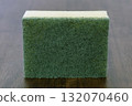 Green scrub sponge kitchen sponge cleaning sponge household scrubber dish scrub abrasive pad dual layer foam core green texture wooden table surface with tidy mood 132070460