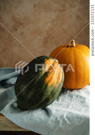 Orange and green pumpkins, rustic wooden moody background, autumn concept 132072131