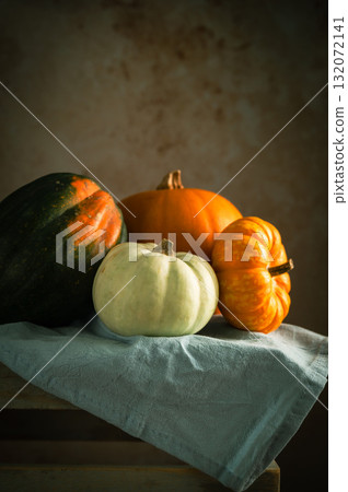 Orange, white and green pumpkins, rustic wooden moody background, autumn concept 132072141