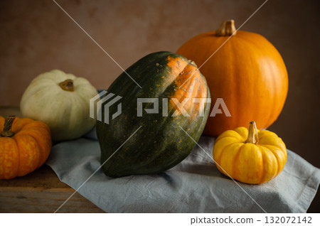 Orange, white and green pumpkins, rustic wooden moody background, autumn concept 132072142