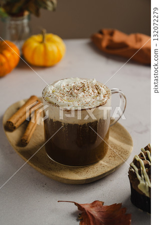 Pumpkin spice latte in glass mug with whipped cream and cinnamon, autumn hot drink 132072279