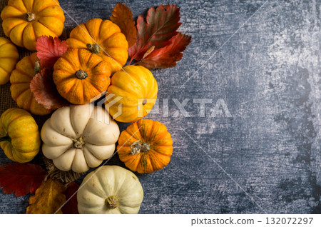 Autumn background. Orange and white mini pumpkins over blue background. Top view 132072297