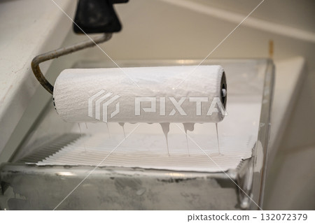 Paint Roller Loaded with White Paint in Tray 132072379