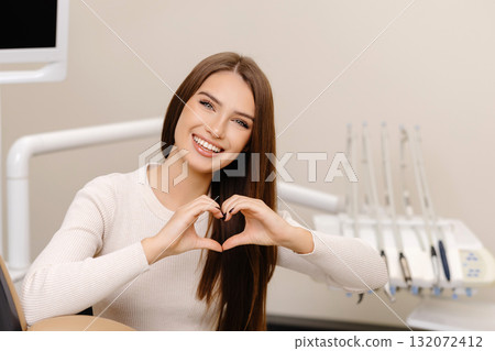 Patient is smiling and gesturing hands heart in dentist office Patient is smiling and gesturing hands heart in dentist office 132072412