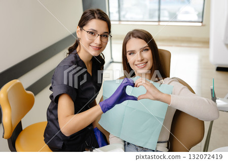 Doctor and patient are doing heart with hands in office. The doctor is grateful for the trust Doctor and patient are doing heart with hands in office. The doctor is grateful for the trust 132072419
