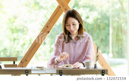 A woman eating sweets at a cafe 132072559