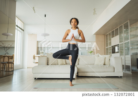 Yoga fitness workout training. Healthy African girl practicing yoga at home. Woman training Pilates doing sports exercise on yoga mat indoor. Girl have training workout for weight loss. Sport fitness 132072801