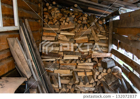 Woodpile of chopped firewood stacked inside a rustic wooden shed Woodpile of chopped firewood stacked inside a rustic wooden shed 132072837