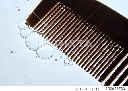 A comb with hair serum. The photo shows the texture of the cosmetic product. 132073780