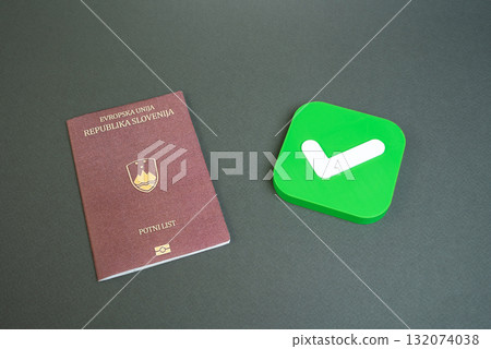 Slovenian passport and approval check mark. Permission to enter or exit. Approval for obtaining a passport or citizenship. Permission for citizens to enter the country of arrival. 132074038