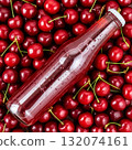 Fresh cherry juice bottle surrounded by ripe cherries on a wooden surface ready for summer enjoyment 132074161