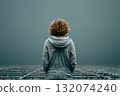 Young woman standing in empty space with gray background and soft light 132074240