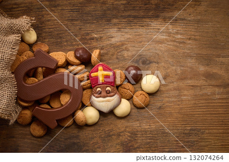 Sinterklaas, St. Nicholas bag filled with a cookies letter S of chocolate and sweets 132074264