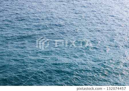 Vast, calm ocean water with gentle ripples and sunlit reflections Vast, calm ocean water with gentle ripples and sunlit reflections 132074457