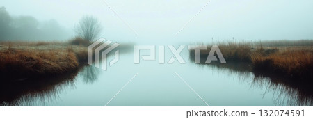 Calm river landscape with mist and reflection in autumn morning light 132074591