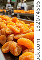 Close-up of dried apricots on industrial conveyor in factory 132074595