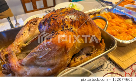 Juicy Thanksgiving turkey served on a festive table, surrounded by delicious side dishes, showcasing a warm and inviting holiday atmosphere 132074665