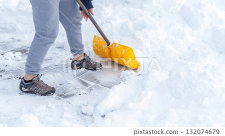 Man shoveling snow off of his driveway after a winter storm in Canada. Man with snow shovel cleans sidewalks in winter. Winter time. Man shoveling snow off of his driveway after a winter storm in Canada. Man with snow shovel cleans sidewalks in winter. Winter time. 132074679