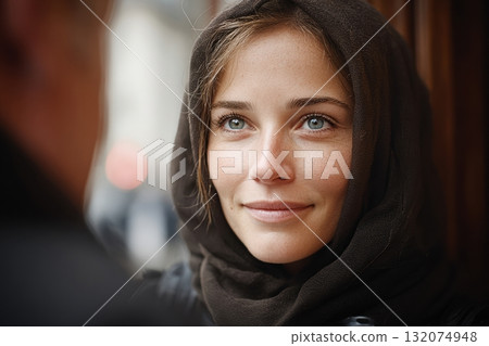 Young woman with headscarf smiling warmly in urban environment 132074948