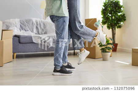 Couple in love embrace at new apartment home together in first moving day Couple in love embrace at new apartment home together in first moving day 132075096