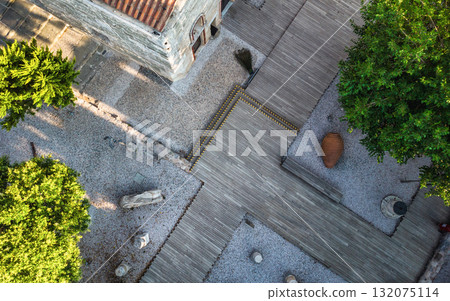 An aerial, top-down view of a courtyard featuring a weathered st 132075114
