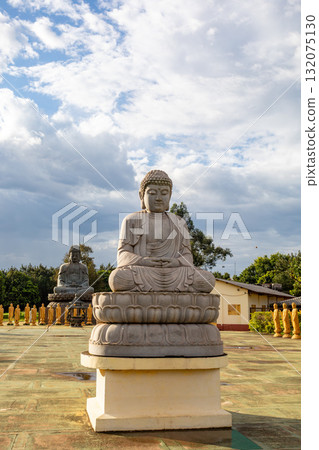 Golden and stone Buddha statues creating a sacred, contemplative space of the Templo Budista Chen Tien, Foz do Iguacu, Brazil. 132075130
