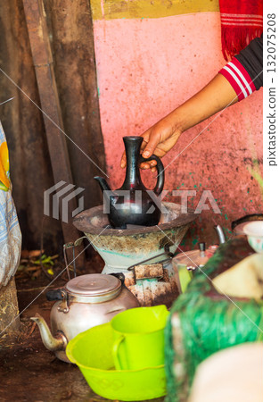 Hand holding a traditional Ethiopian coffee pot, Jebena, during the coffee ceremony in Amhara Region, Ethiopia. 132075208