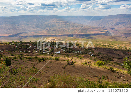 Ethiopian village and farmed terraces against a backdrop of breathtaking, layered canyons. Ethiopia 132075230