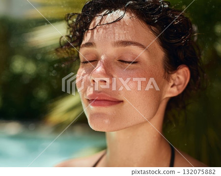 Woman with closed eyes enjoys poolside sun, showcasing smooth skin and wet hair. Perfect for summer beauty and relaxation themes. 132075882