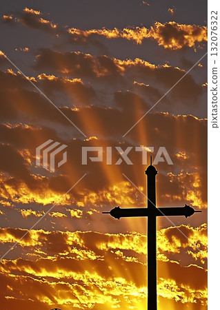 Cross is silhouetted against a beautiful sunset 132076322