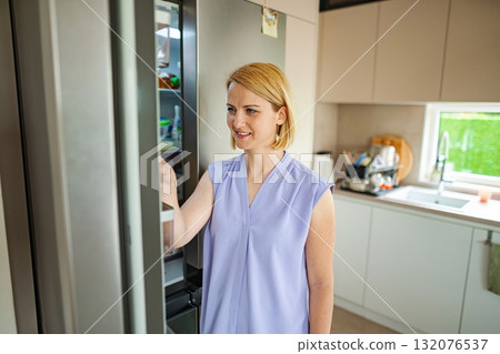 Woman discovers fresh ingredients in her kitchen space Woman discovers fresh ingredients in her kitchen space 132076537