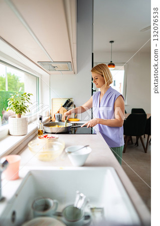 Joyful cooking moment in a modern kitchen setting Joyful cooking moment in a modern kitchen setting 132076538