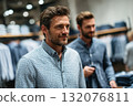 Stylish man shopping for shirts in modern clothing store with racks 132076811