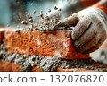 Skilled worker laying bricks with mortar in construction site environment 132076820