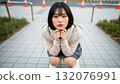 一名女子蹲在街上，目光專注 132076991