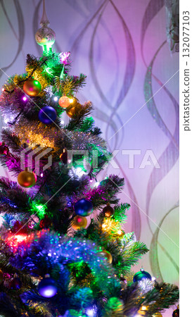 Brightly decorated Christmas tree with colorful lights and ornaments indoors. Festive holiday atmosphere and New Year mood Brightly decorated Christmas tree with colorful lights and ornaments indoors. Festive holiday atmosphere and New Year mood 132077103