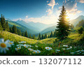 Mountain landscape with blooming white daisies in green meadow, tall evergreen tree, forested hills, and sunlit peaks under partly cloudy sky with copy space 132077112