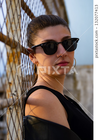 Urban portrait of modern woman with buildings in blurred background. 132077413
