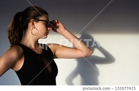 Dreamy fashion portrait with sunlight and shadows on concrete wall, perfect for minimalist campaigns, boutique brands, and aesthetic magazines. Dreamy fashion portrait with sunlight and shadows on concrete wall, perfect for minimalist campaigns, boutique brands, and aesthetic magazines. 132077415